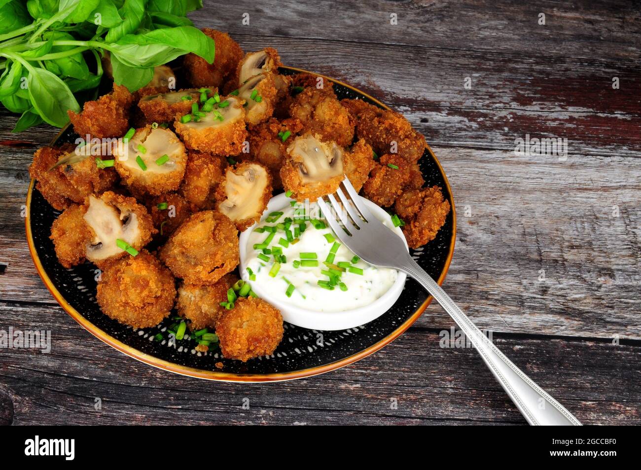 Whole breaded button mushrooms with soured cream and chive dip Stock