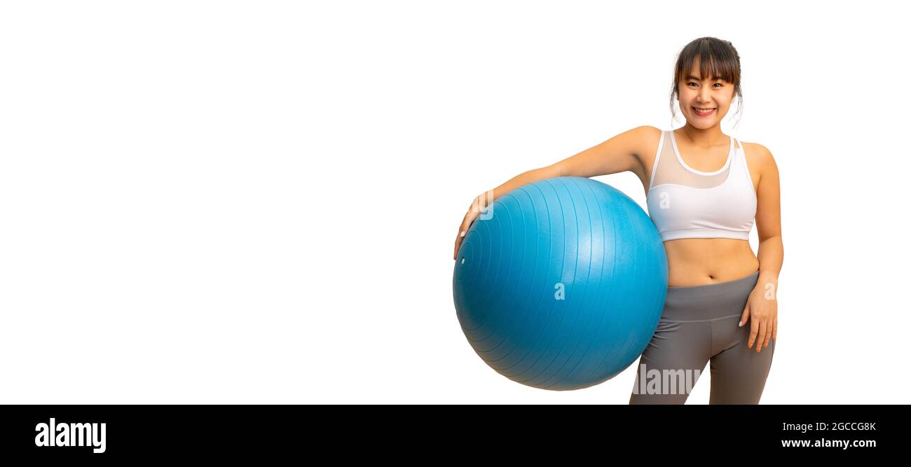 Young happy and healthy Asian woman holding pilates exercise ball while ...