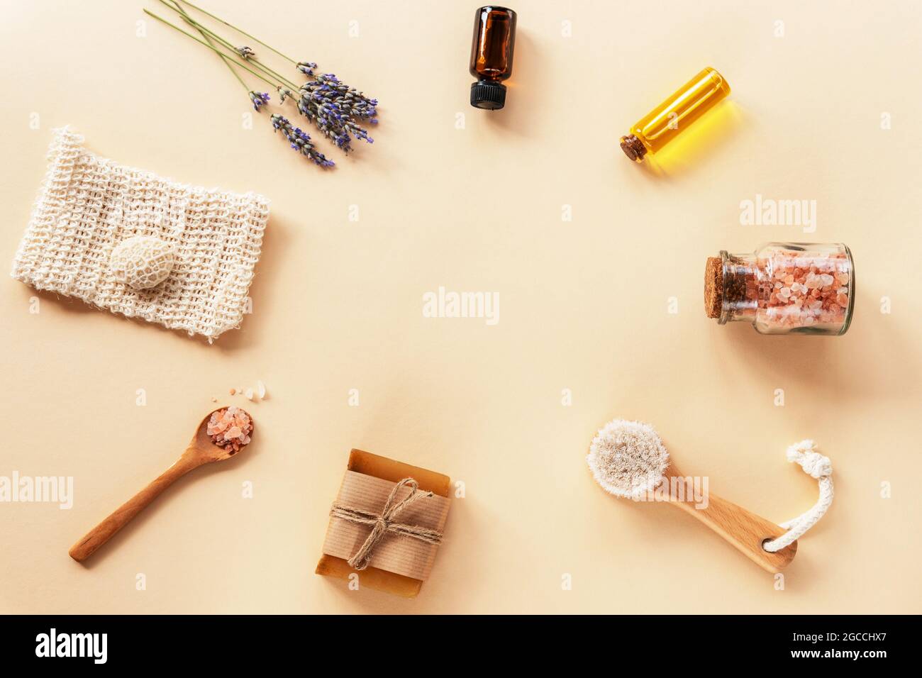 Bath accessories and natural cosmetics, himalayan pink salt in glass jar, essential oil and lavender flowers on beige background. Zero waste concept. Stock Photo