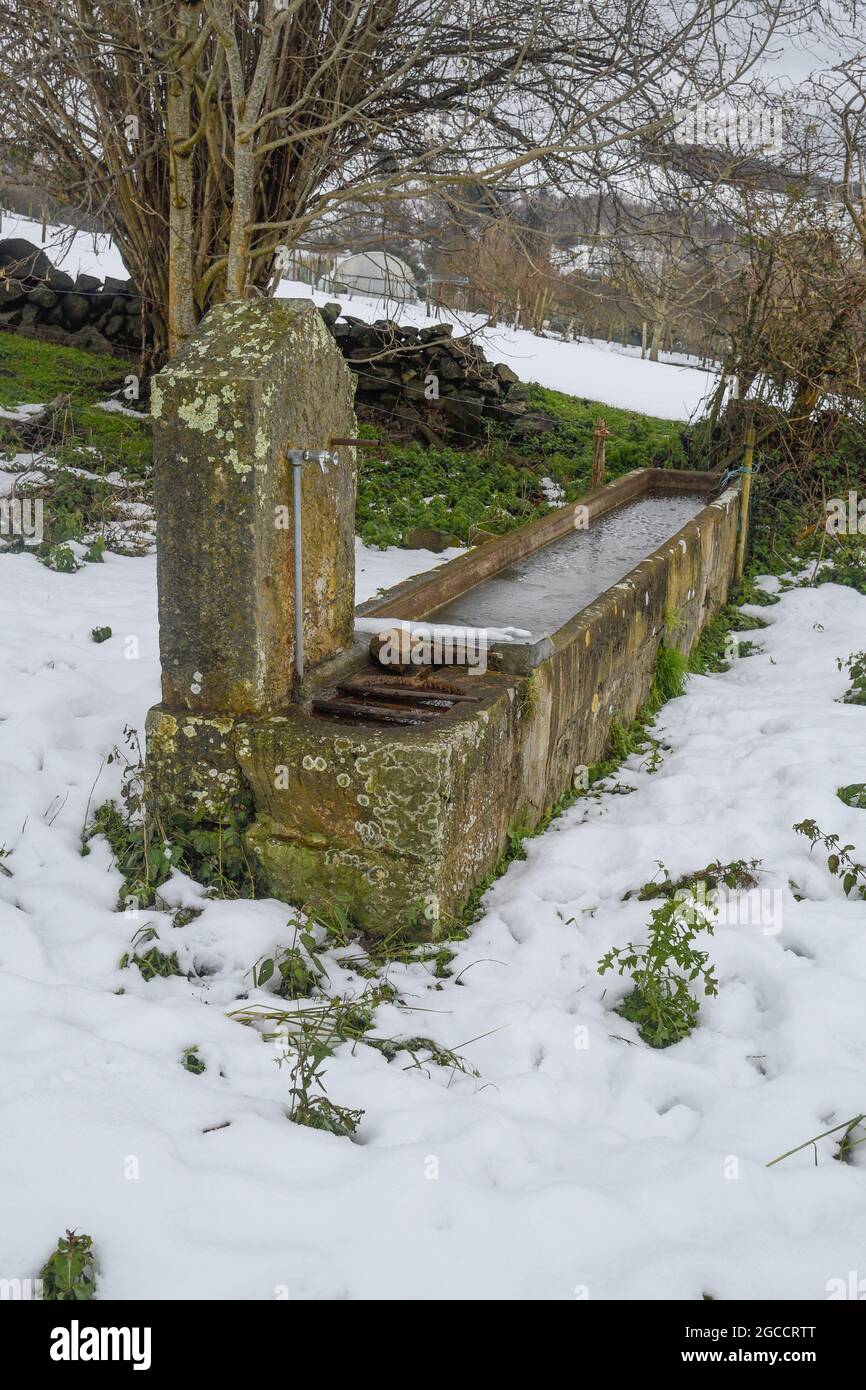 Old watering hole in the snow in San Miguel de Linares, Artzentales Stock Photo