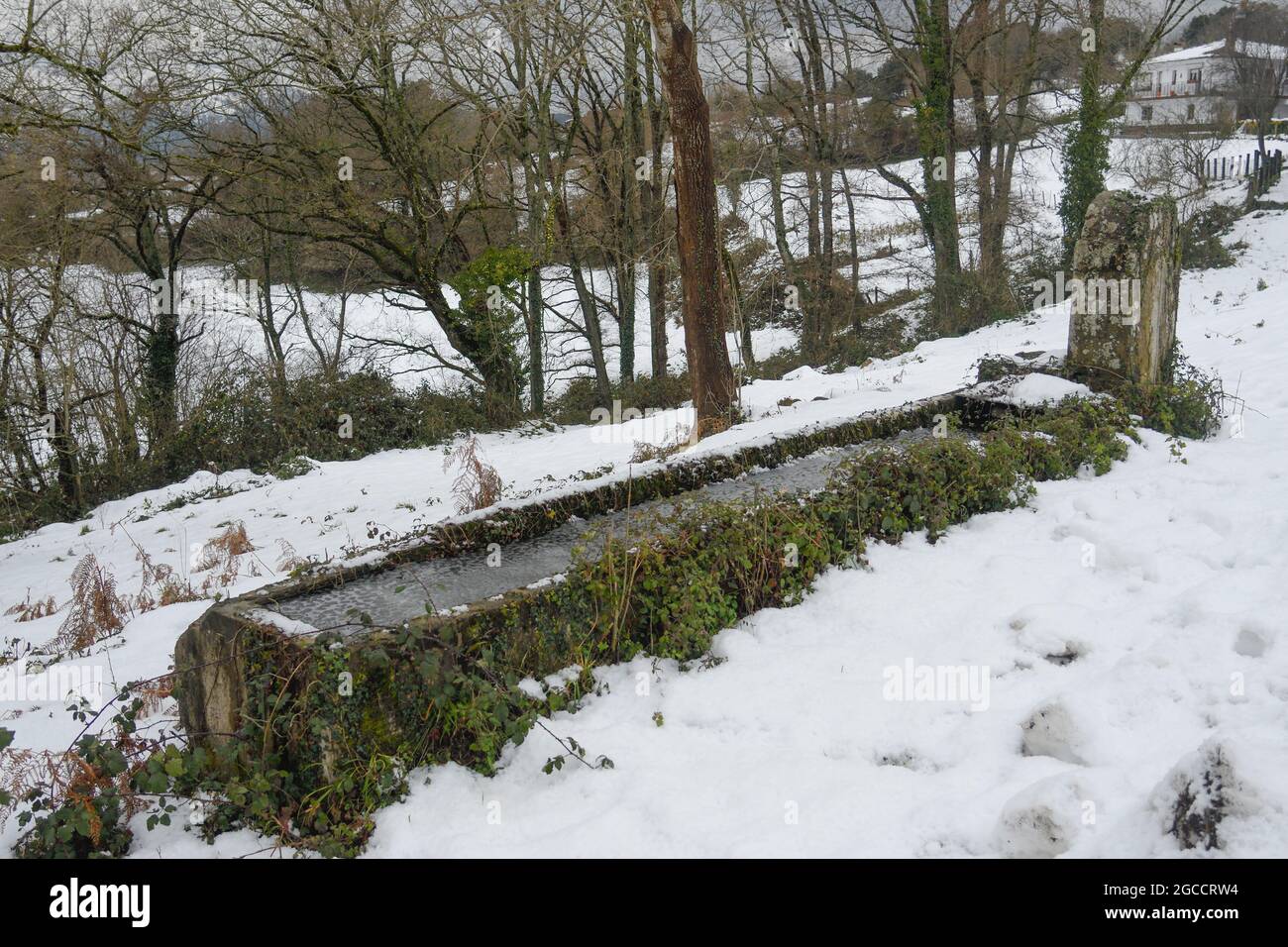 Old watering hole in the snow in San Miguel de Linares, Artzentales Stock Photo