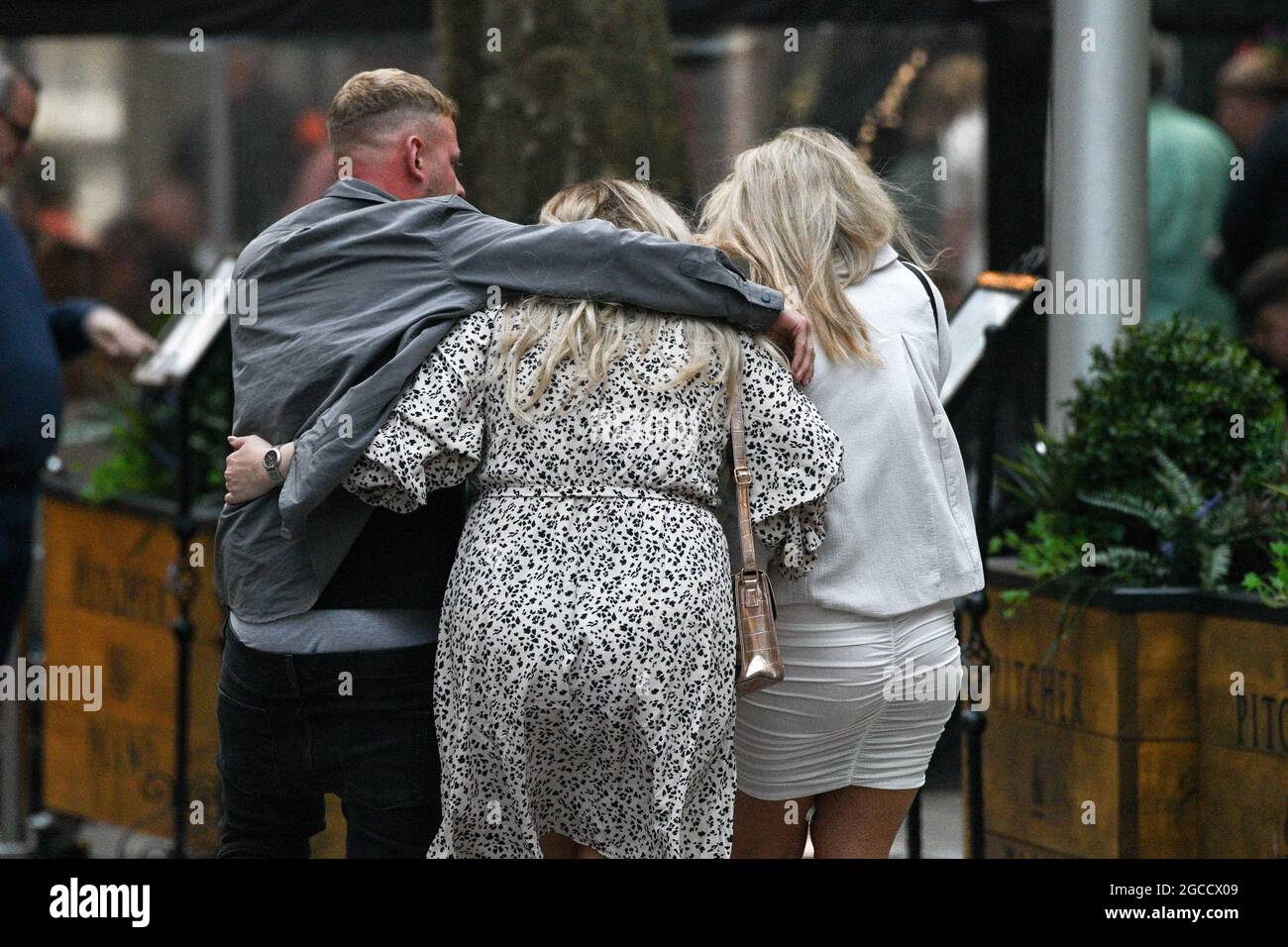 A drunk man holds onto two girls on Wind Street in Swansea, on Saturday night as nightclubs open across Wales for the first time since the start of the pandemic, as well as facemask restriction being no longer mandatory inside pubs. Stock Photo