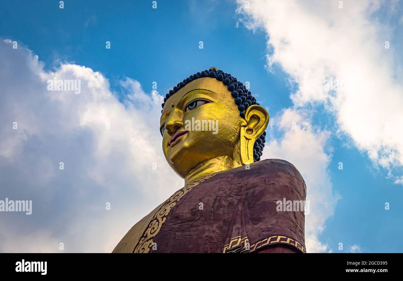 huge buddha golden statue from different perspective with bright blue sky at evening image is taken at giant buddha statue tawang arunachal pradesh in Stock Photo
