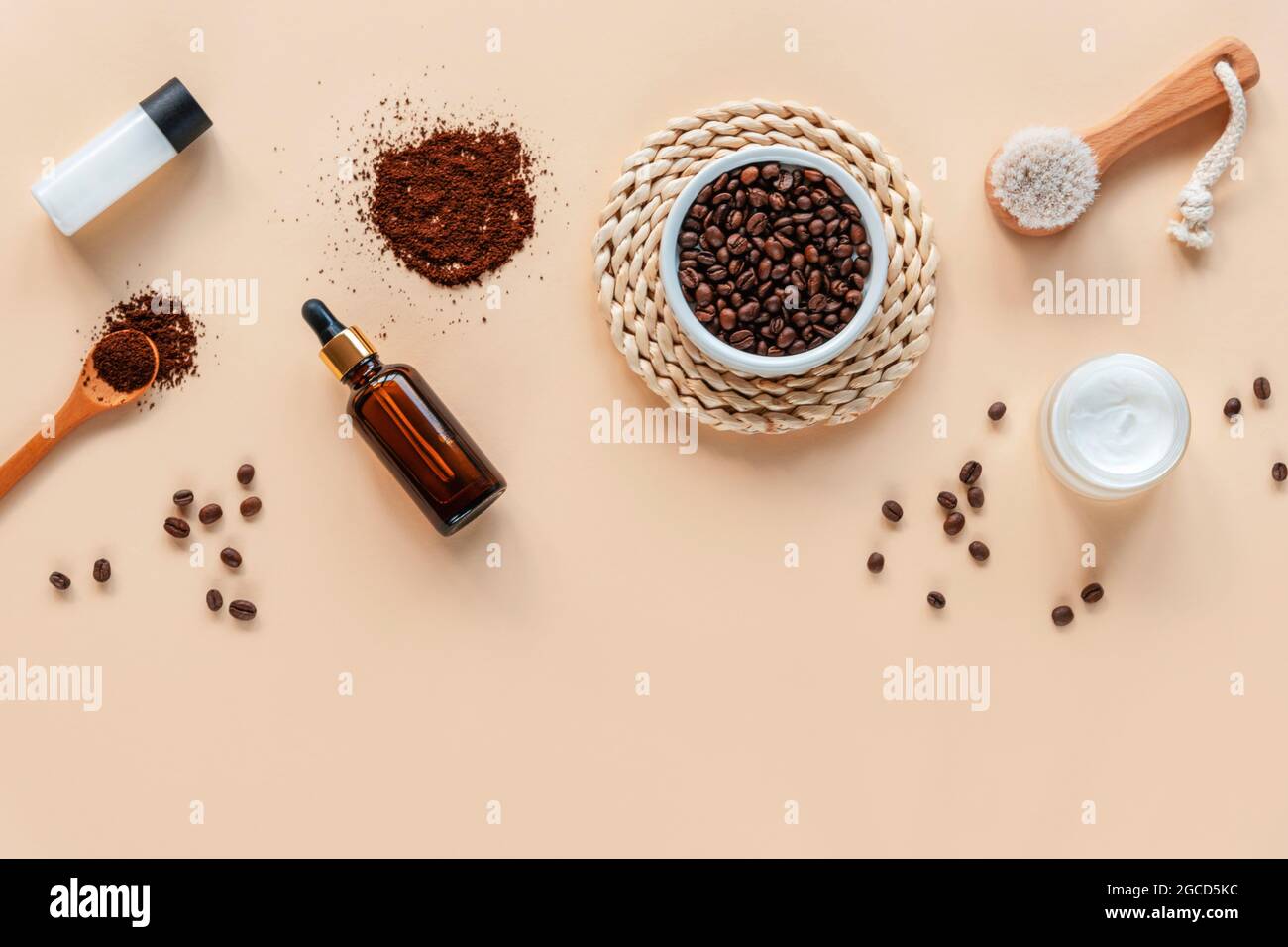 Bath accessories and natural cosmetics, ingredients for coffee scrub, face brush, serum bottle on beige background with copy space. Top view, flat lay Stock Photo