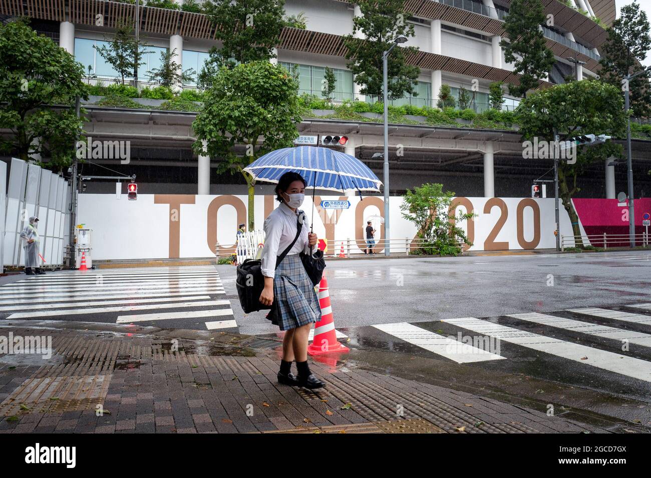 A Japanese High school girl with an umbrella walks past the Tokyo National Stadium on the last day of Tokyo Olympics Games. (Photo by Tanja Houwerzijl / SOPA Images/Sipa USA) Stock Photo