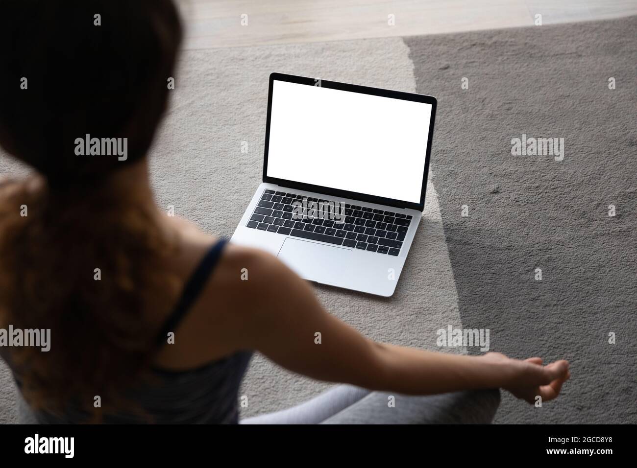 Top view woman practicing yoga online, laptop with empty screen Stock Photo
