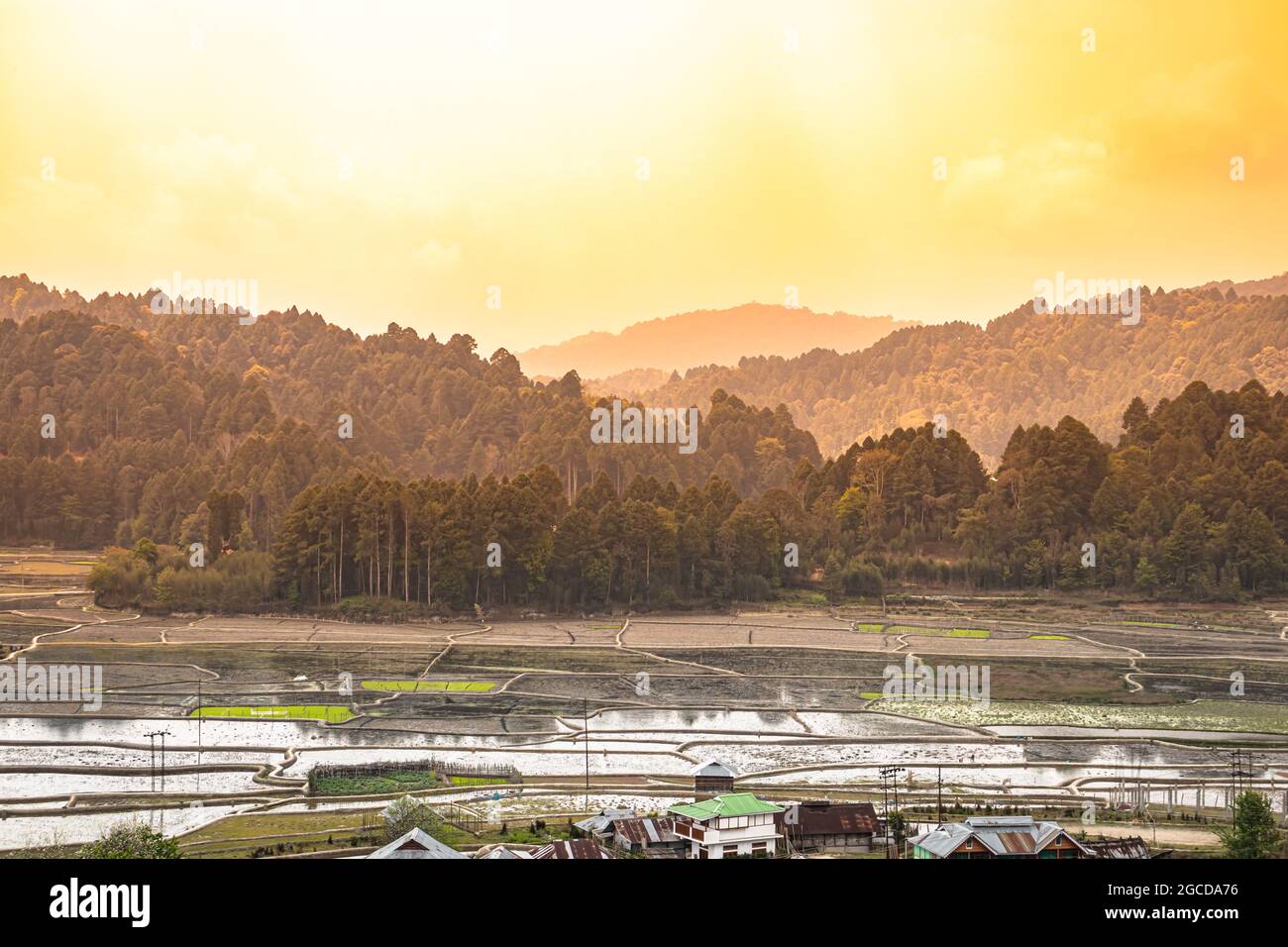 country side paddy fields and village with mountain backdrop at morning image is taken at ziro arunachal pradesh india. Stock Photo