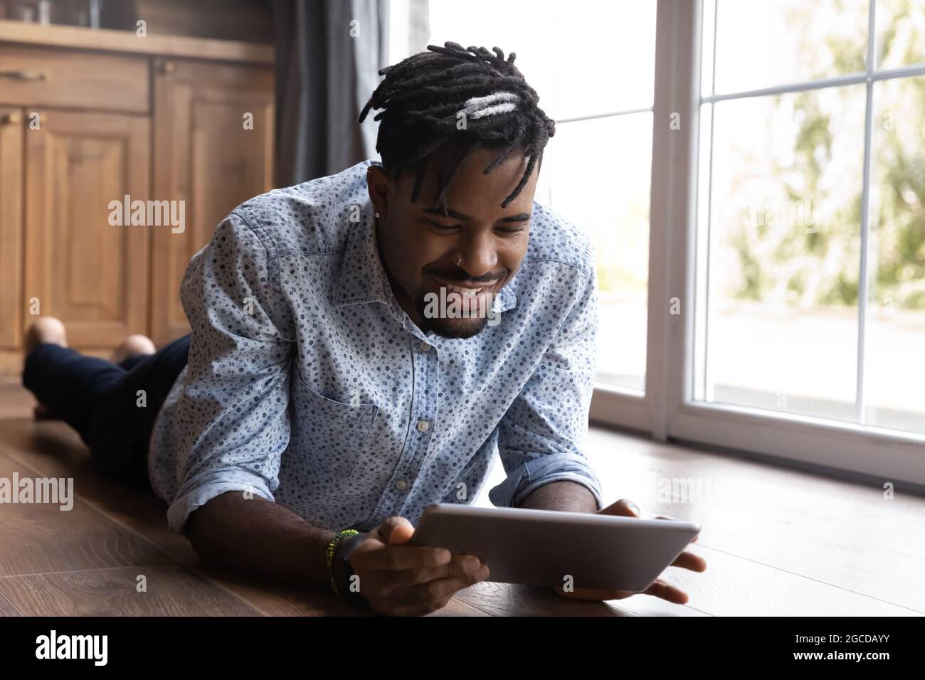 Smiling biracial man use tablet talking on webcam call Stock Photo