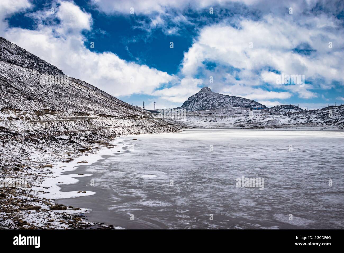 frozen sela lake with snow cap mountains and bright blue sky at