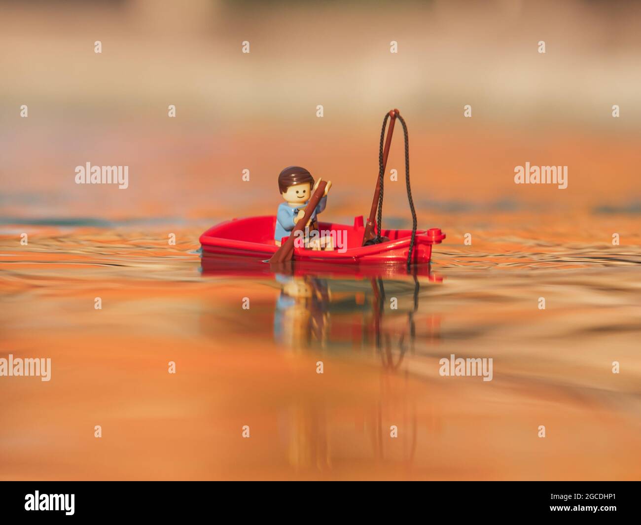 Lego minifigure swimming on red boat Stock Photo