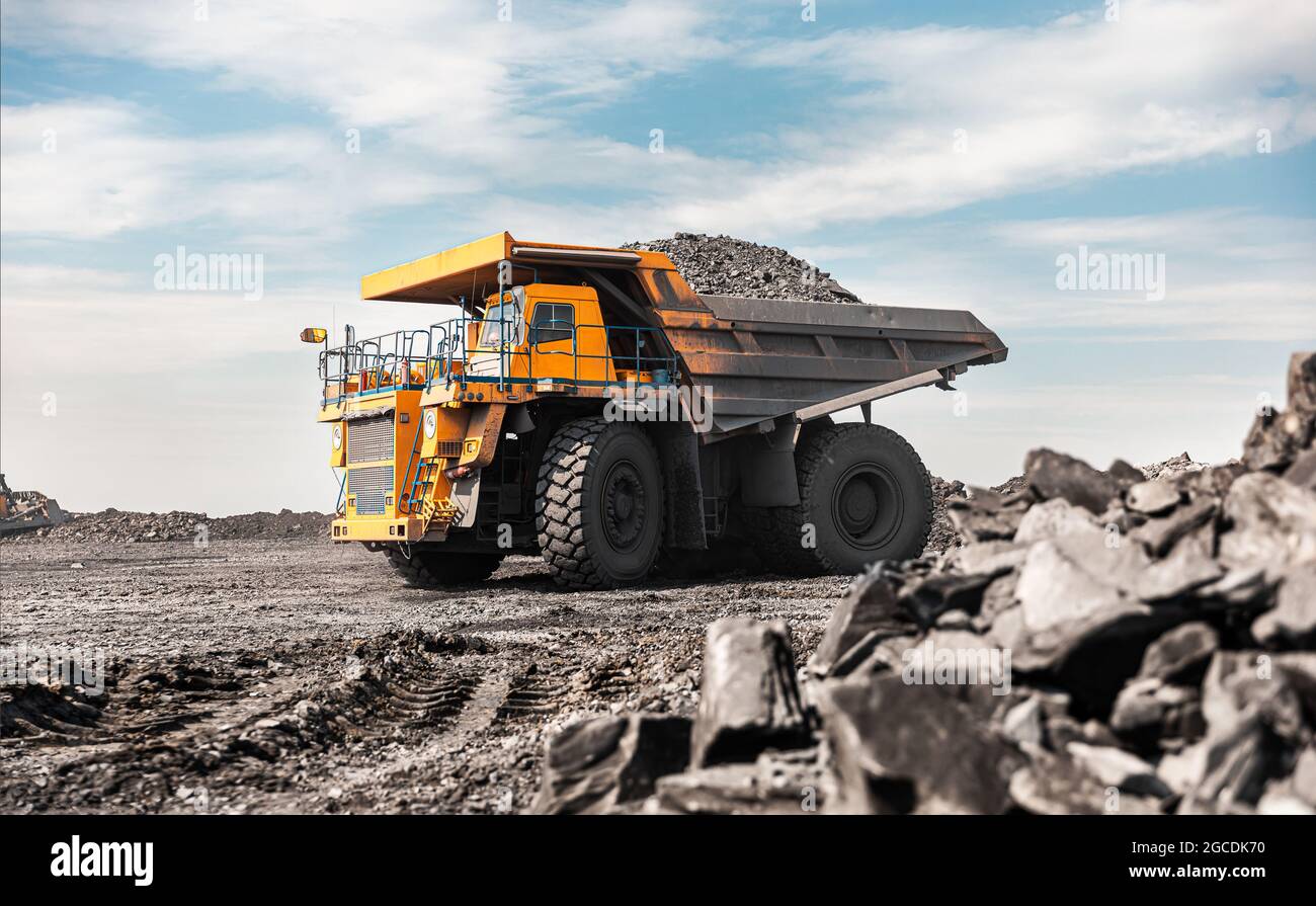 Large quarry dump truck. Big yellow mining truck at work site. Loading