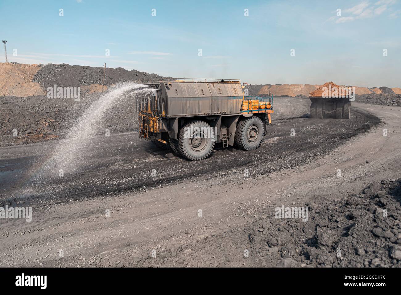 Watering machine cutaway. Large quarry dump truck. Big yellow mining truck at work site. Production useful minerals. Mining truck mining machinery to Stock Photo
