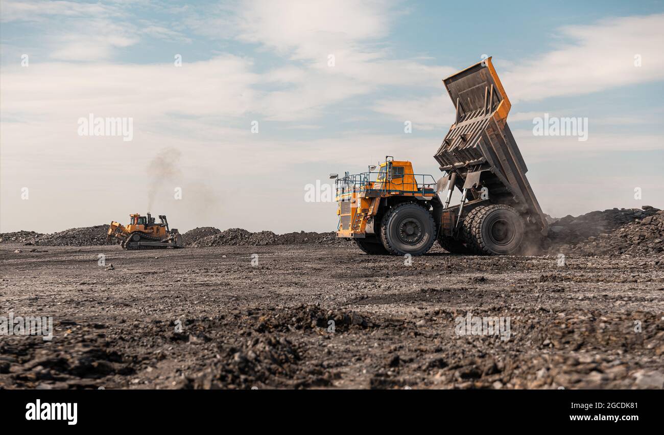 Large quarry dump truck. Big yellow mining truck at work site. Loading ...