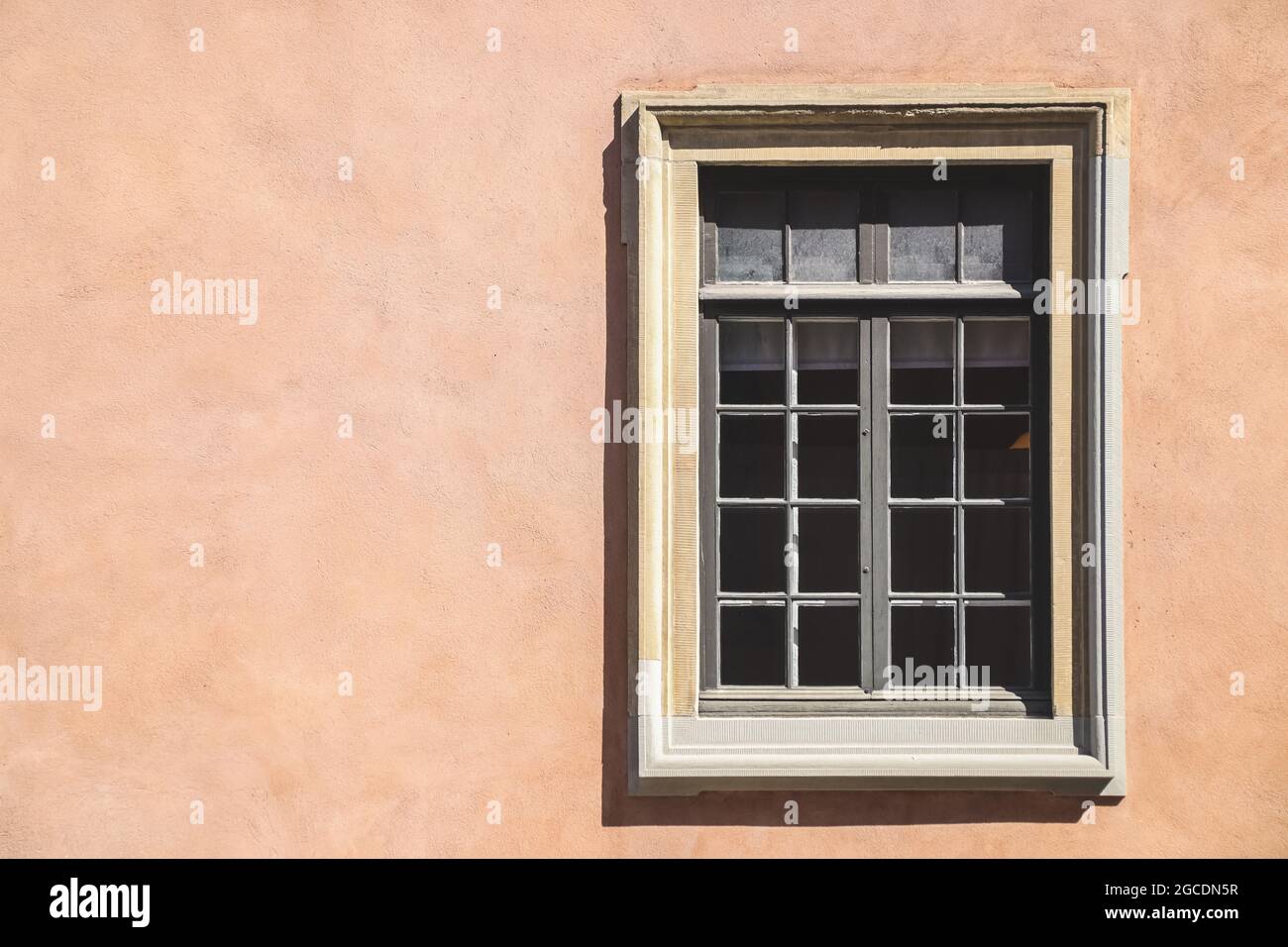 One white window of an orange ancient building Stock Photo