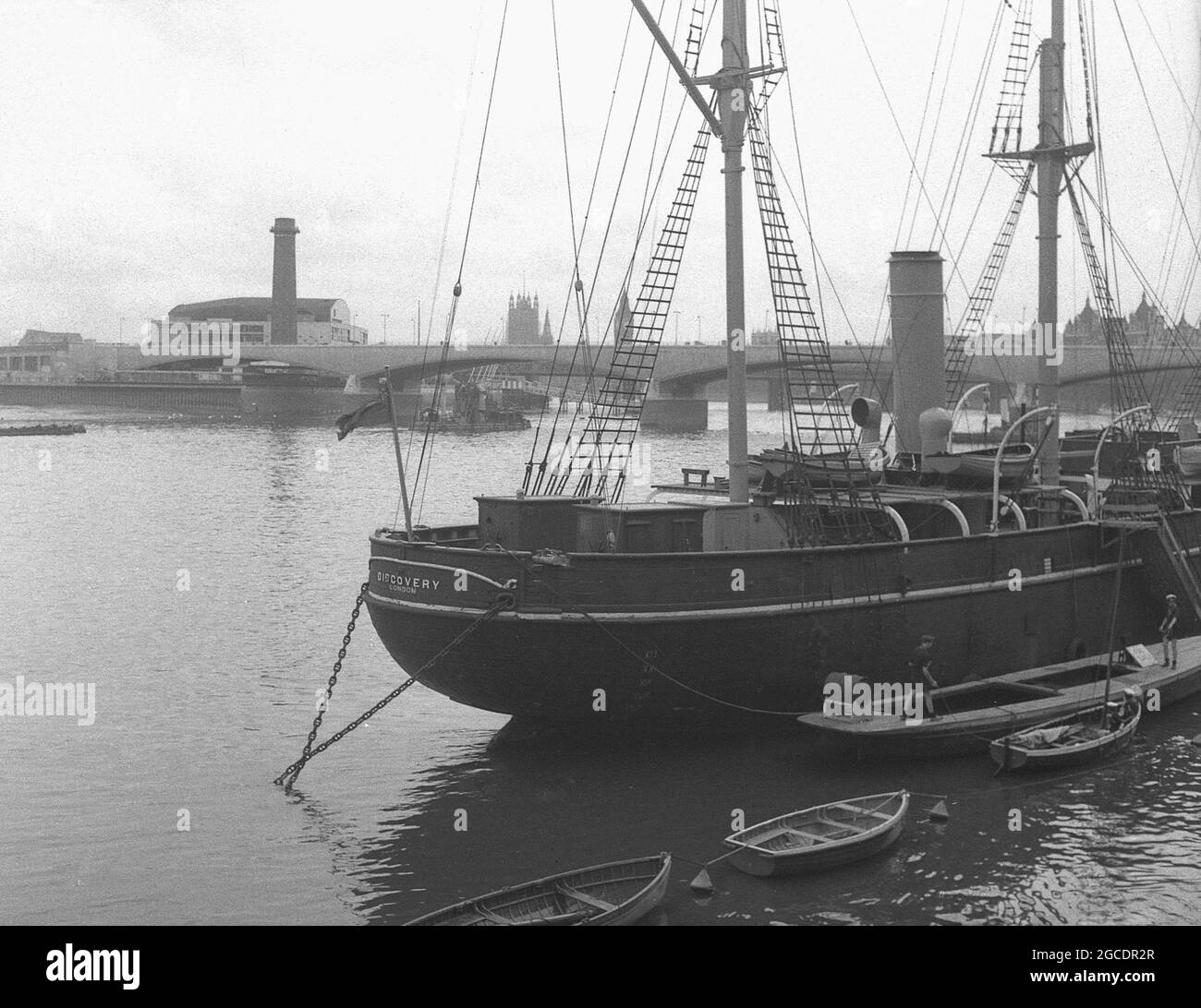 1950s, historical view of the famous barque-rigged sailing ship, 'RRS Discovery' on the river Thames, London, England, UK, the last wooden three-masted ship to be built in Britain. A sailing vessel wth auxillary steam propulsion, she was constructed in Dundee, Scotland. Built specially for Antartic research, her first journey, known as the Discovery Expedition (1901-1904) carried British explorers Robert Falcon Scott and Ernest Shackletone to the region. After being in the Australian Antartic from 1929 to 1931, she was then moored on the Thames as a static training ship and visitor attraction. Stock Photo