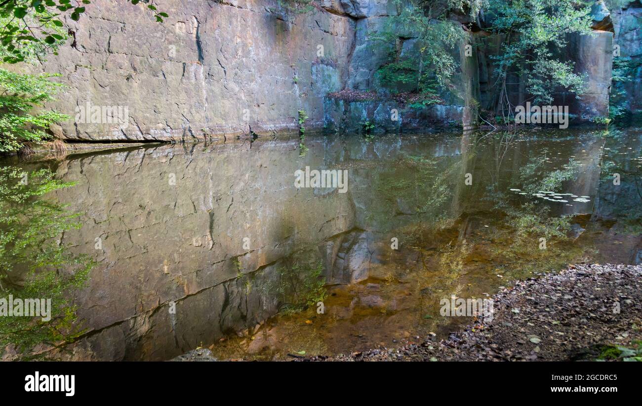 abstract reflection of rocks in calm water in a remote place nature ...