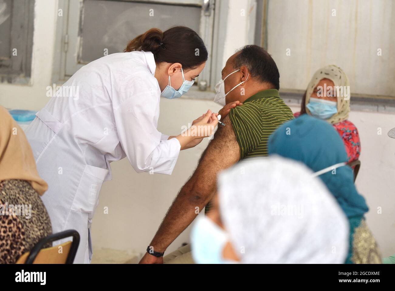 Tunis, Tunisia. 08th Aug, 2021. A health worker administers the AstraZeneca vaccine to a Tunisian man at Oued Ellil high school in Manouba. The national Covid-19 vaccination day for people aged 40 and above started this Sunday, August 8, 2021, in various parts of Tunisia. Credit: SOPA Images Limited/Alamy Live News Stock Photo