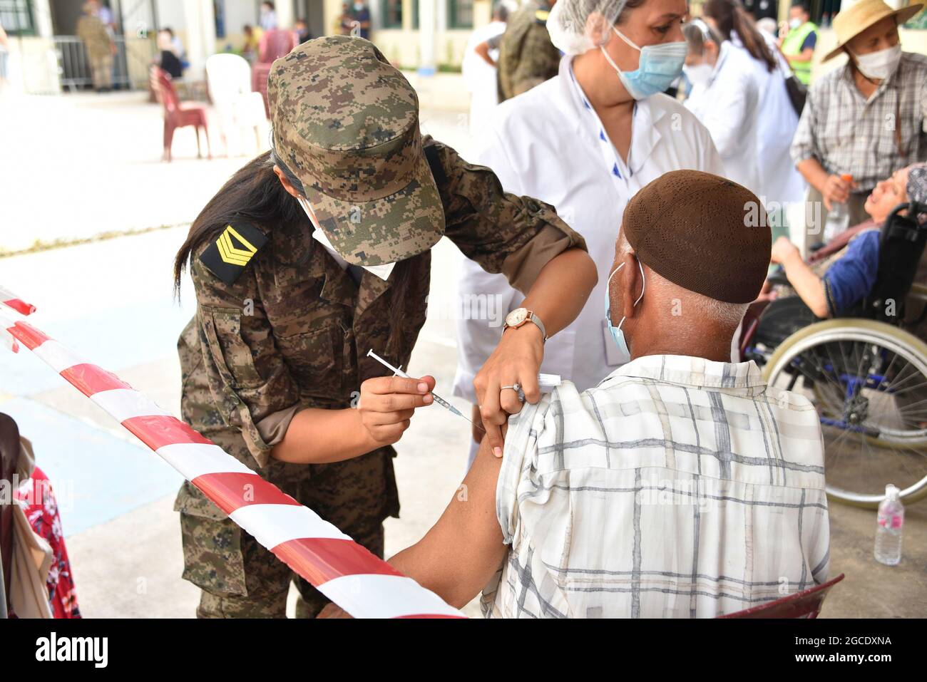 Tunis, Tunisia. 08th Aug, 2021. An army officer administers the AstraZeneca vaccine to a Tunisian man at Oued Ellil high school in Manouba. The national Covid-19 vaccination day for people aged 40 and above started this Sunday, August 8, 2021, in various parts of Tunisia. Credit: SOPA Images Limited/Alamy Live News Stock Photo