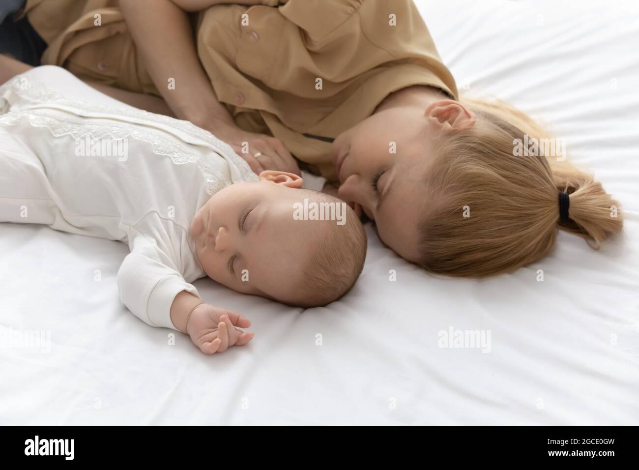 Young Caucasian mother and newborn baby sleep in bed Stock Photo Alamy