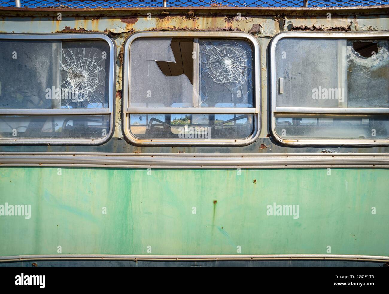 Abandoned old bus close up, side view. Vintage pattern with peeled paint and broken glass Stock Photo
