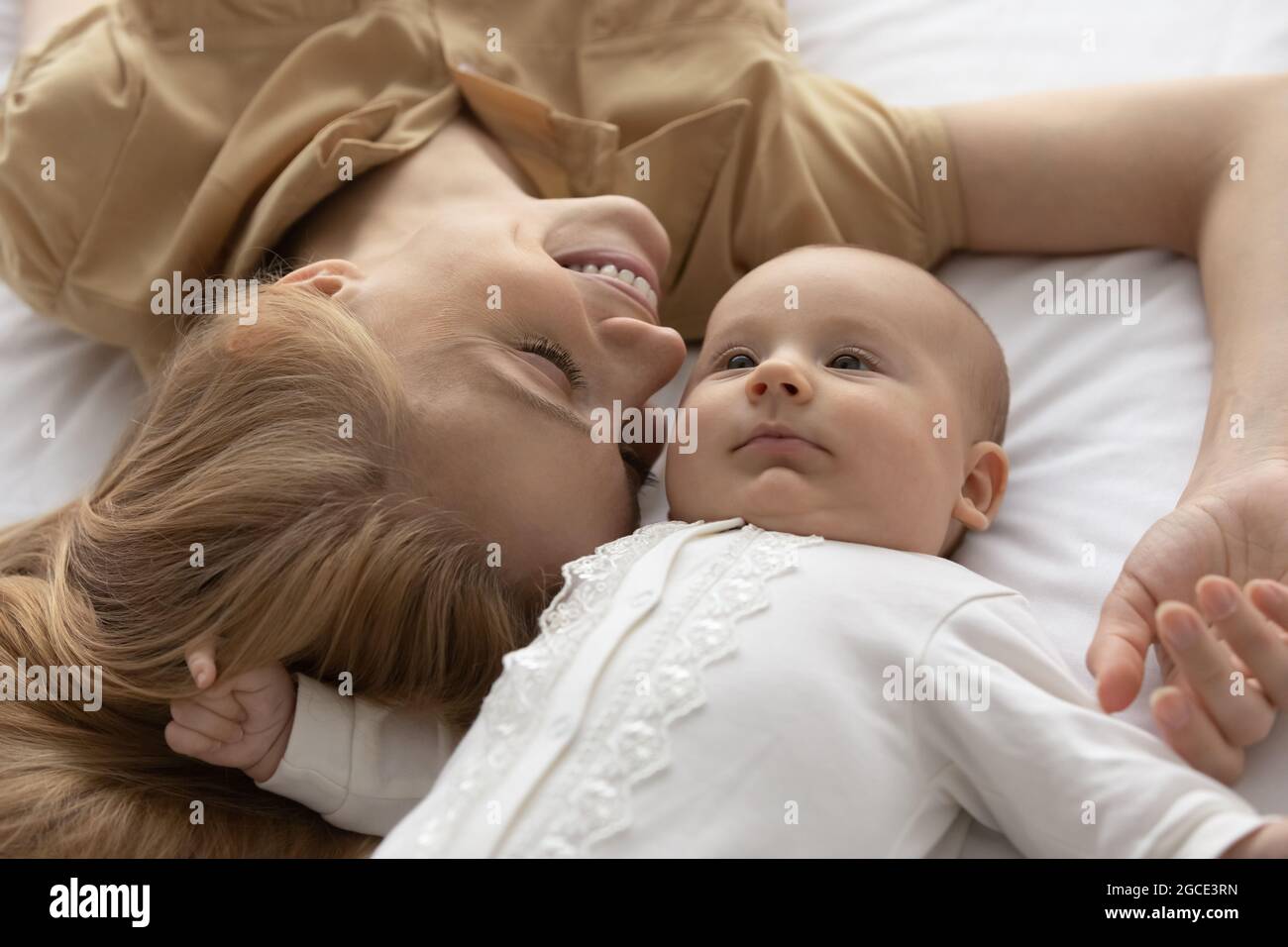Happy young mom and newborn baby cuddle in bedroom Stock Photo Alamy