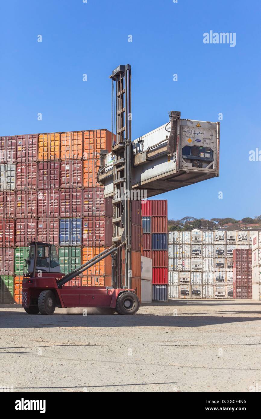 Steel Shipping containers stack in yard with vehicle  fork lifter machine in open yard. Stock Photo