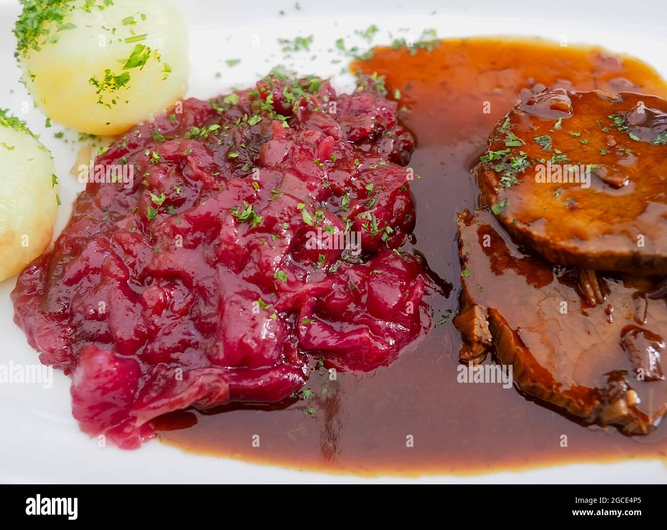 Delicious cooking: Roast beef with sauce, red cabbage and potato dumplings Stock Photo