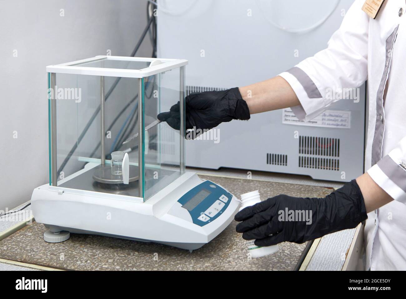 Scientist weighing chemicals by digital scales in grams in chemical laboratory Stock Photo