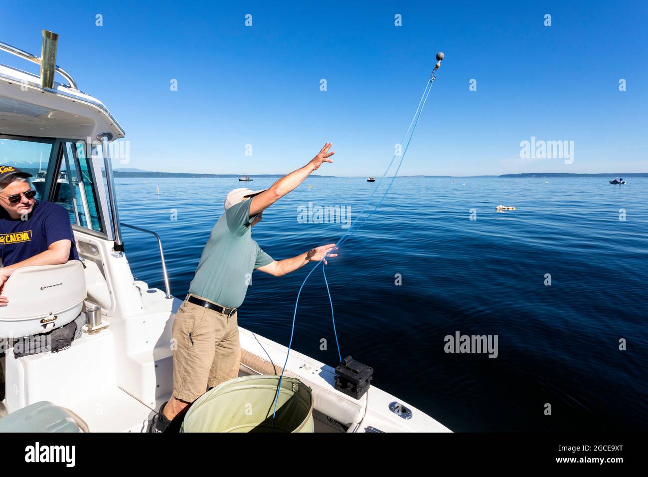 WA20274-00.....WASHINGTON - Phil Russell tosses out a line weight attached to a shrimp pot in the Puget Sound. Stock Photo