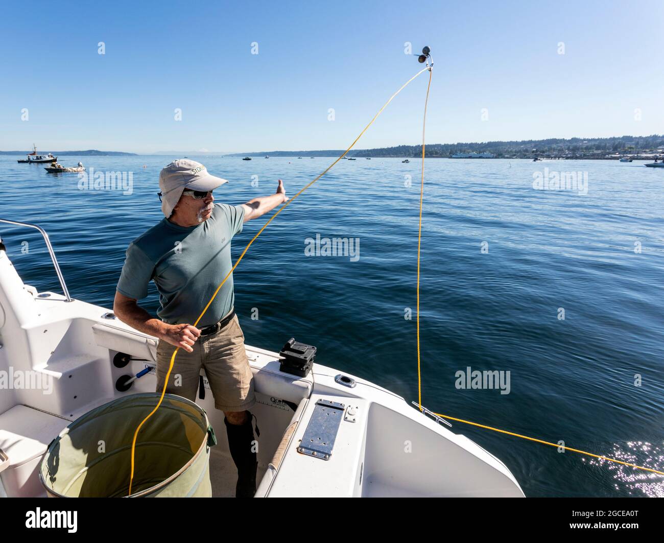 WA20275-00.....WASHINGTON - Phil Russell tosses out a line weight attached to a shrimp pot in the Puget Sound. Stock Photo