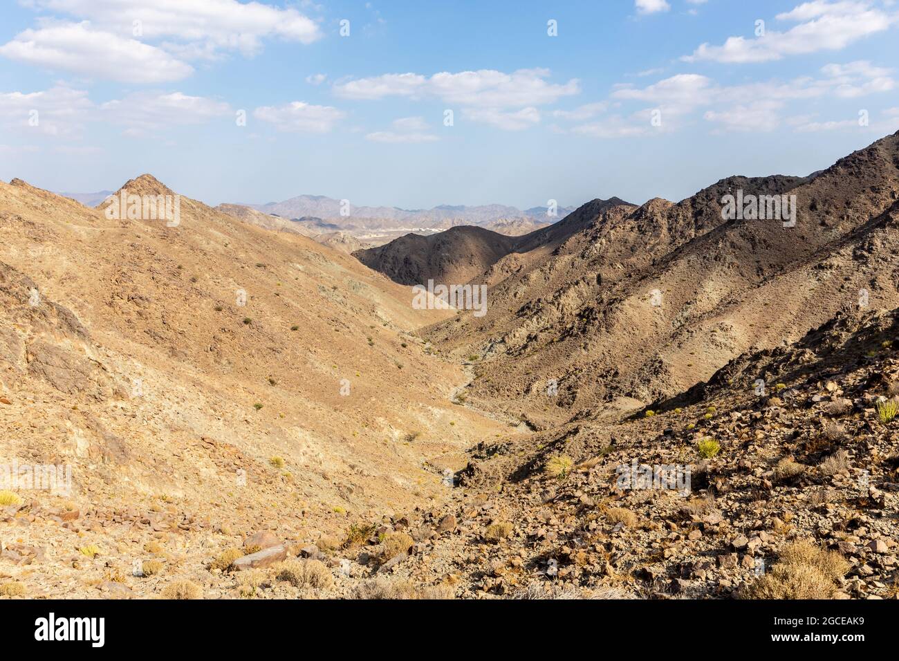 Al Hajar Mountains landscape seen from Copper Hike Summit, with rocky, dry riverbed (wadi) and barren mountain ridges, Hatta, United Arab Emirates. Stock Photo