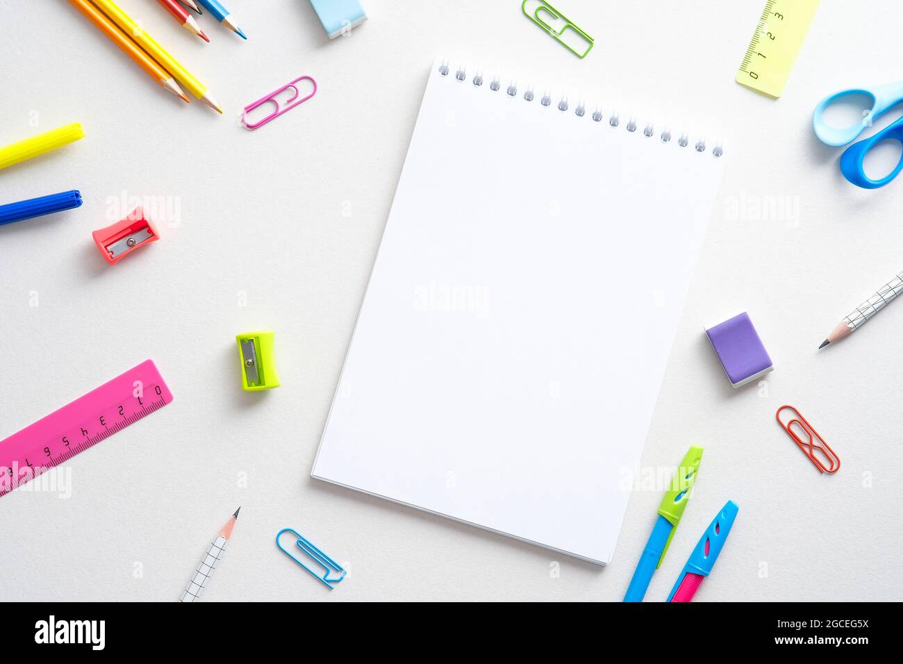 Flat lay colorful school supplies and paper notepad on white background ...
