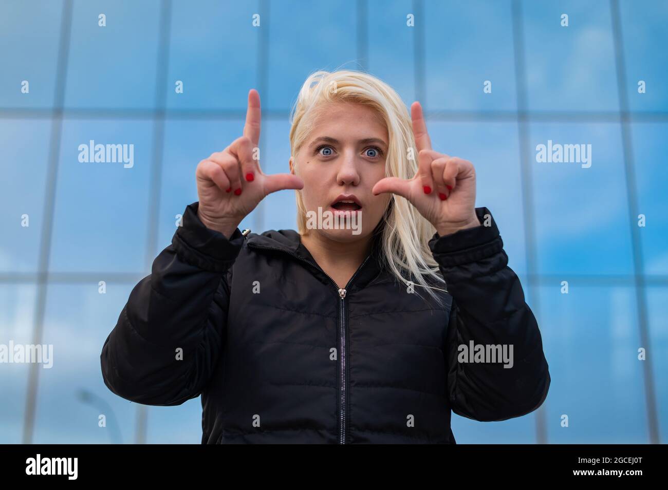 Emotional deaf and dumb woman talking sign language outdoors. Stock Photo