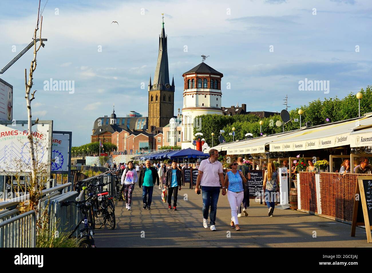 The popular tourist attraction Rhine river promenade with the two landmarks Lambertus Church and Castle Tower in Düsseldorf, Germany. Stock Photo