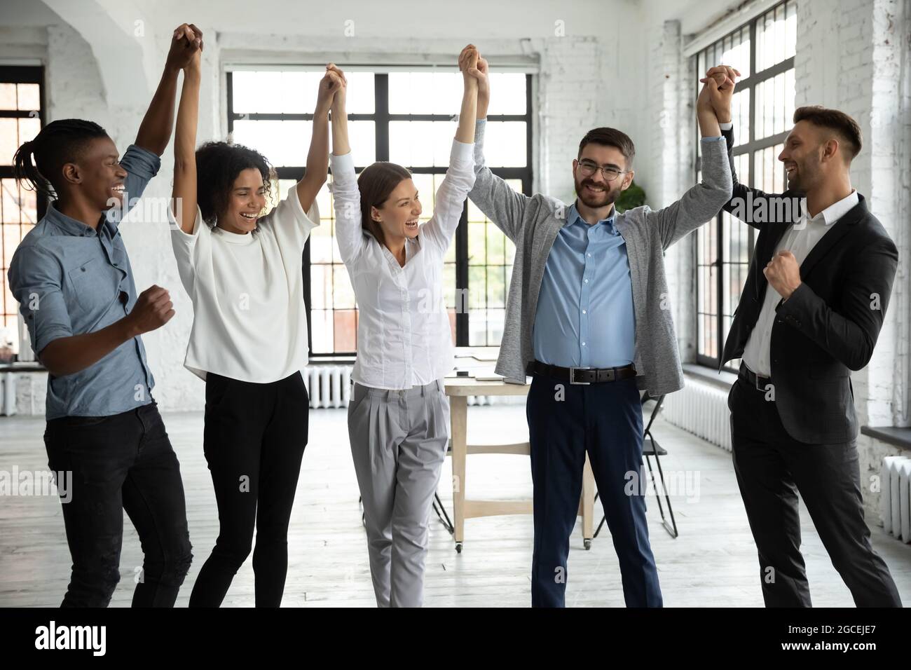 Excited Diverse Employees Celebrate Business Success In Office Stock