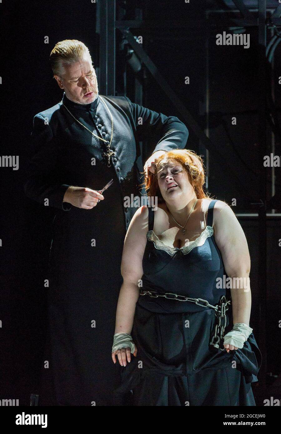 cutting off her hair: James Creswell (Father Superior), Tamara Wilson (Donna Leonora di Vargas) in THE FORCE OF DESTINY by Verdi at English National Opera (ENO), London Coliseum WC2  09/11/2015  a co-production with Metropolitan Opera, New York & Canadian Opera Company, Toronto  conductor: Mark Wigglesworth  new English translation by Jeremy Sams  set design: Rebecca Ringst  costumes: Inga Krugler  video design: Sarah Derendinger  lighting: Tim Mitchell  director: Calixto Bieito Stock Photo