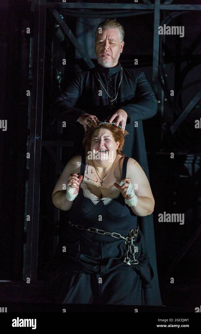 forcing down a crown of thorns: James Creswell (Father Superior), Tamara Wilson (Donna Leonora di Vargas)  in THE FORCE OF DESTINY by Verdi at English National Opera (ENO), London Coliseum WC2  09/11/2015  a co-production with Metropolitan Opera, New York & Canadian Opera Company, Toronto  conductor: Mark Wigglesworth  new English translation by Jeremy Sams  set design: Rebecca Ringst  costumes: Inga Krugler  video design: Sarah Derendinger  lighting: Tim Mitchell  director: Calixto Bieito Stock Photo