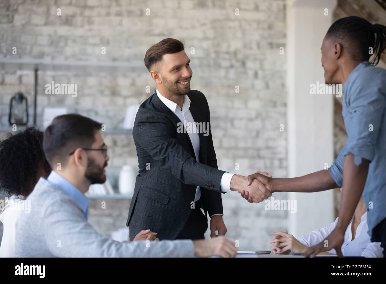Smiling diverse businesspeople handshake at office meeting Stock Photo