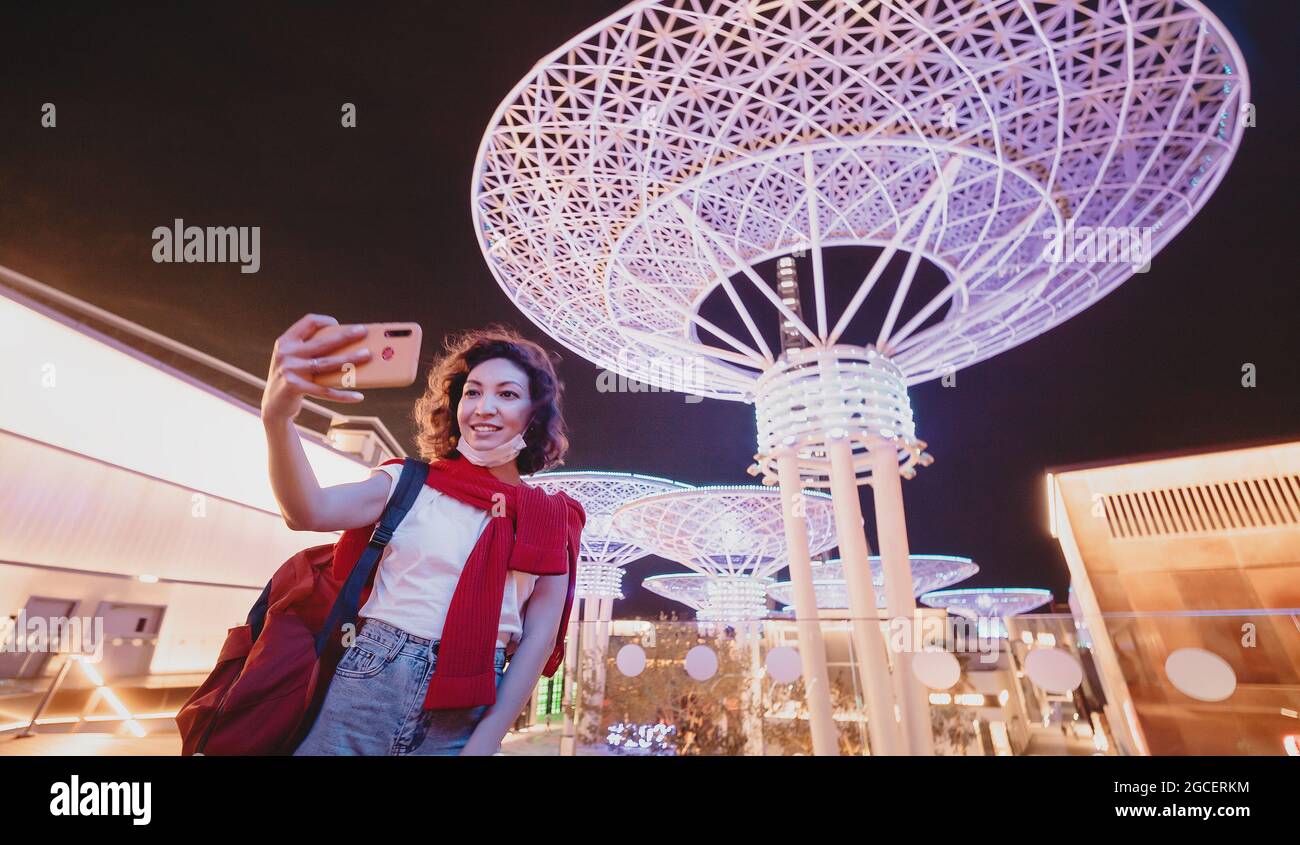 Woman tourist taking selfie photo at famous Dubai tourist Attraction - Neon futuristic glowing metal super trees on bluewaters Island. Stock Photo