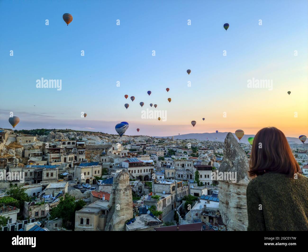 Cappadocia - Turkey, hot air balloons in the sky in the morning, tourism in Turkey. woman watching hot air balloons backwards Stock Photo