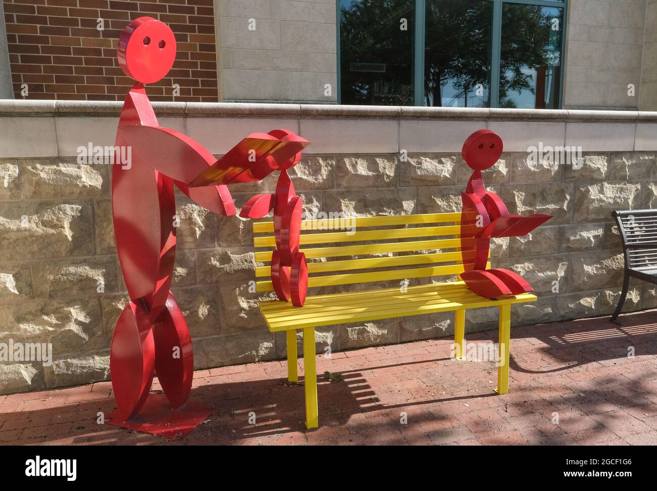 Metal sculptures of adult and two children promoting literacy and reading outside of a public library Georgetown, Texas USA Stock Photo