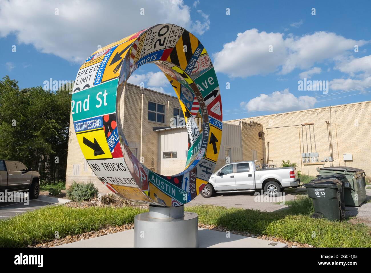 Large metal art sculpture in shape of ring that rotates with wind and decorated with road and street signs Georgetown Texas USA Stock Photo