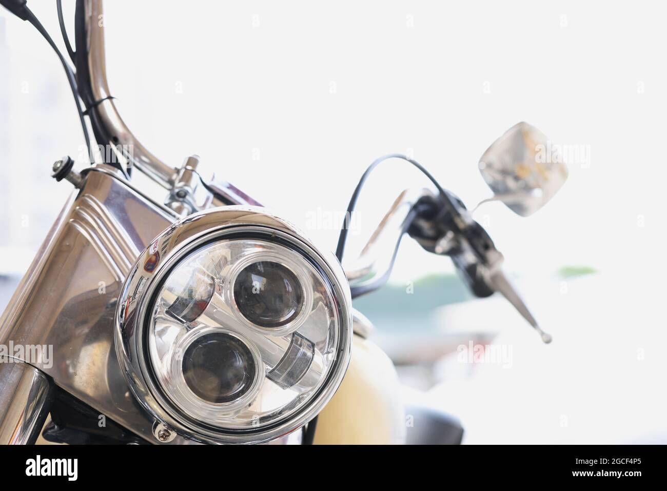 Round motorcycle headlight with handlebars and mirrors closeup Stock Photo