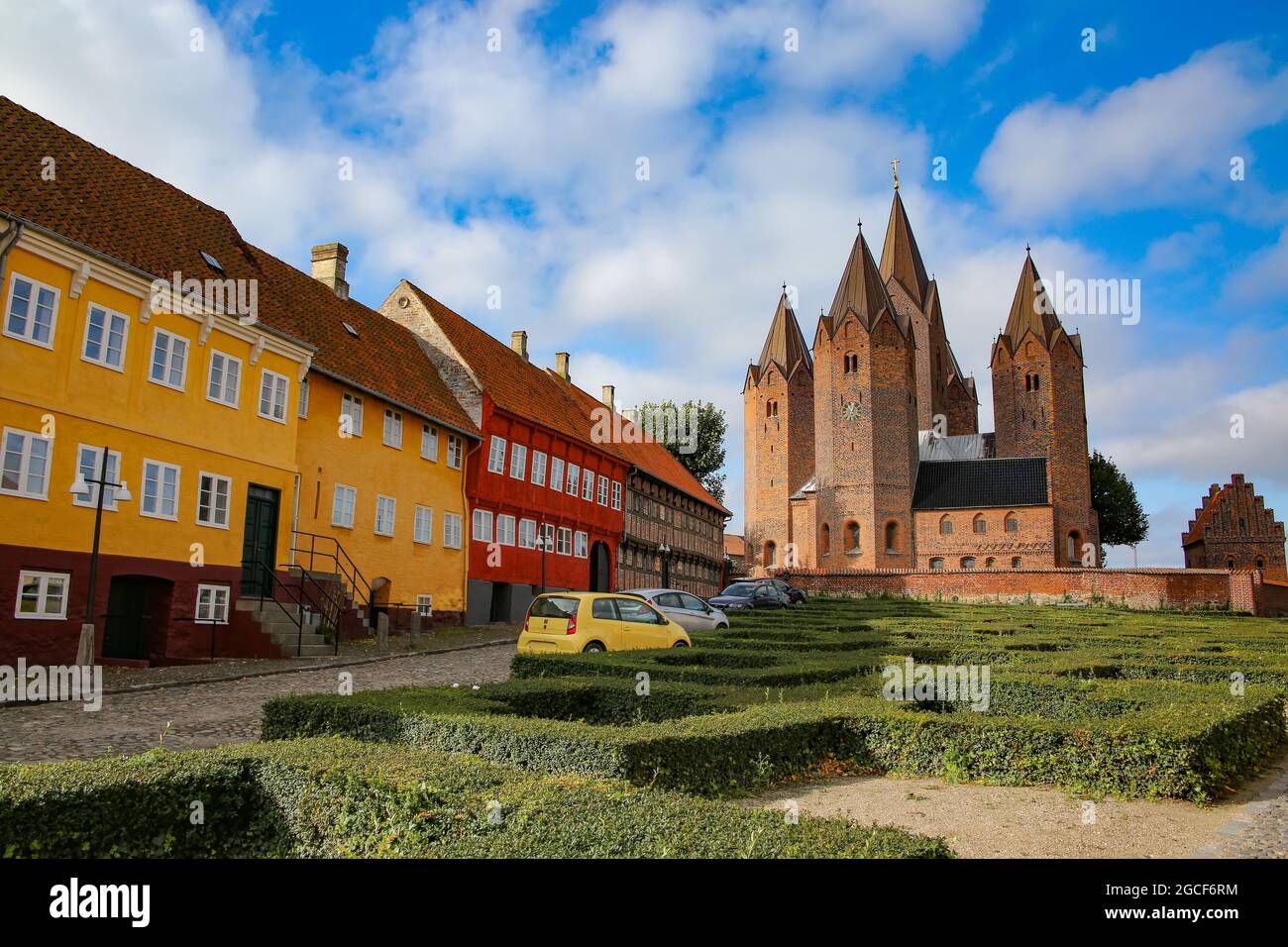 Beautiful street view of the town. Colourful traditonal houses along the road with the Church of Our Lady in the background. Kalundborg, Denmark. Stock Photo