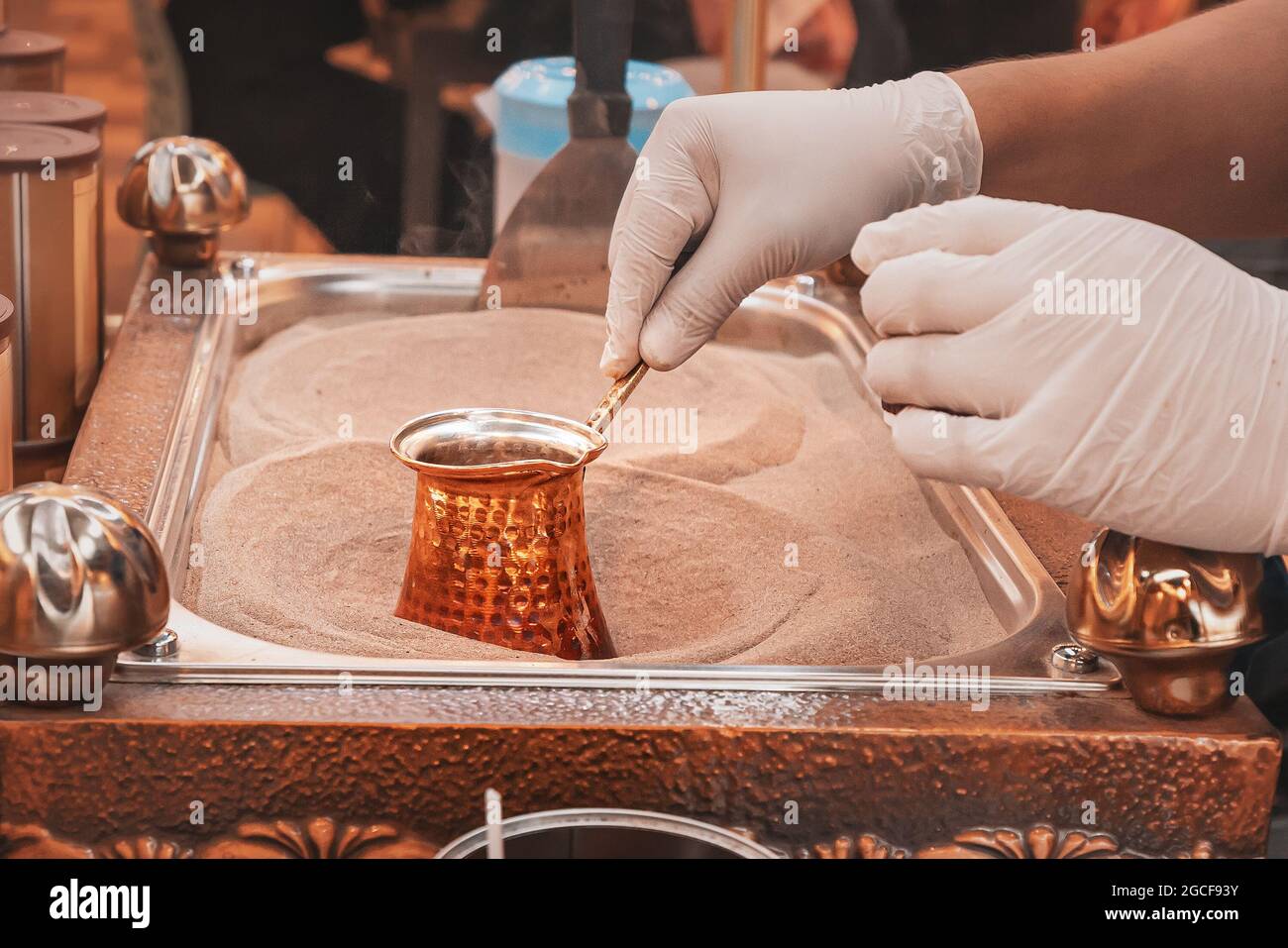 Making coffee in a copper cezve coffee maker on hot sand according to a  traditional Turkish recipe Stock Photo - Alamy
