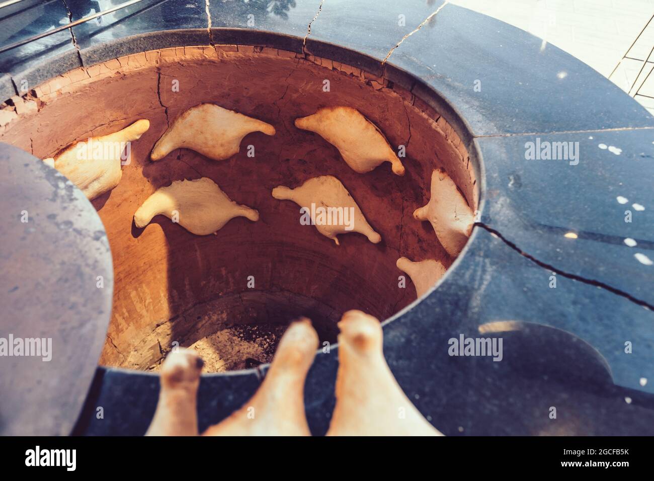 Baking flatbreads for making khachapuri in a traditional tandoor oven