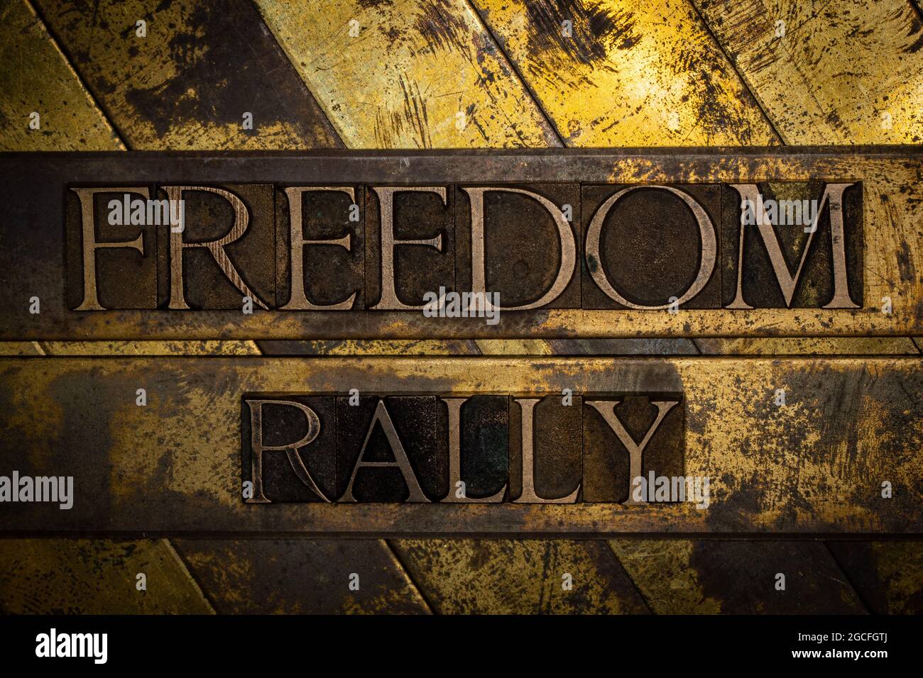 Freedom Rally text message on textured grunge copper and vintage gold background Stock Photo