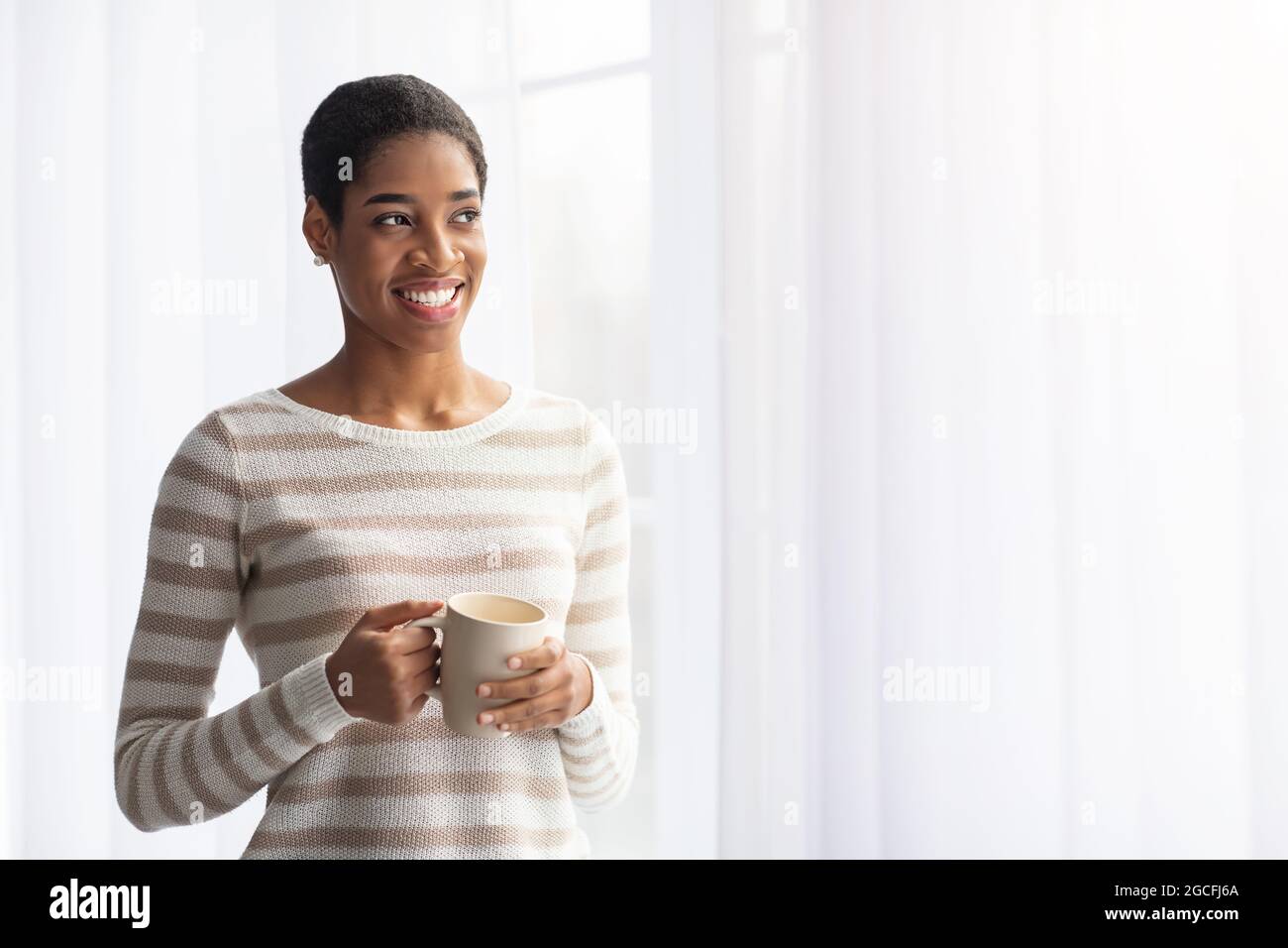 Happy Smiling African American Woman Drinking Coffee While Standing