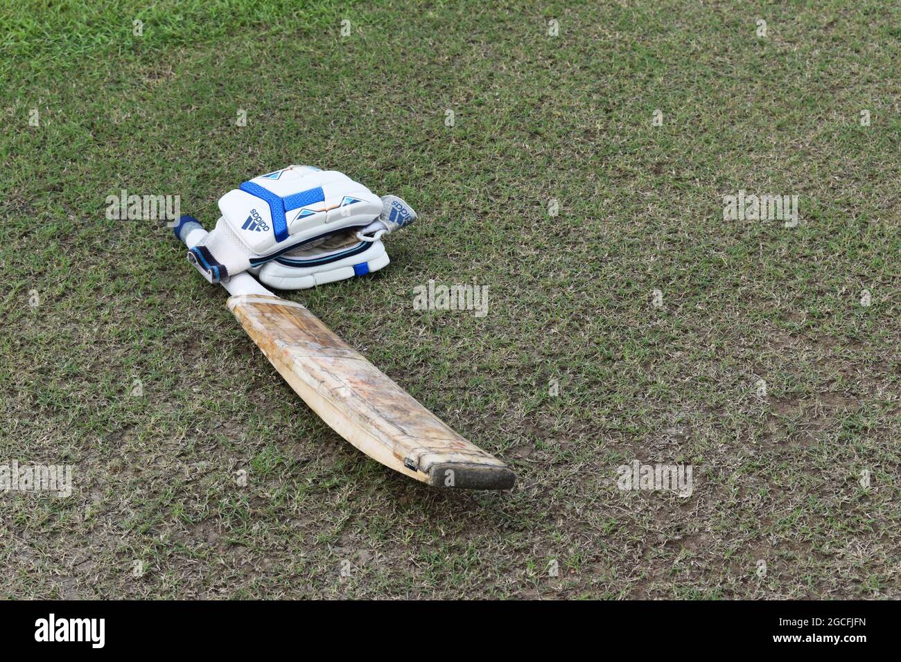 A cricket bat and gloves lying on the ground. Sri Lanka. Stock Photo