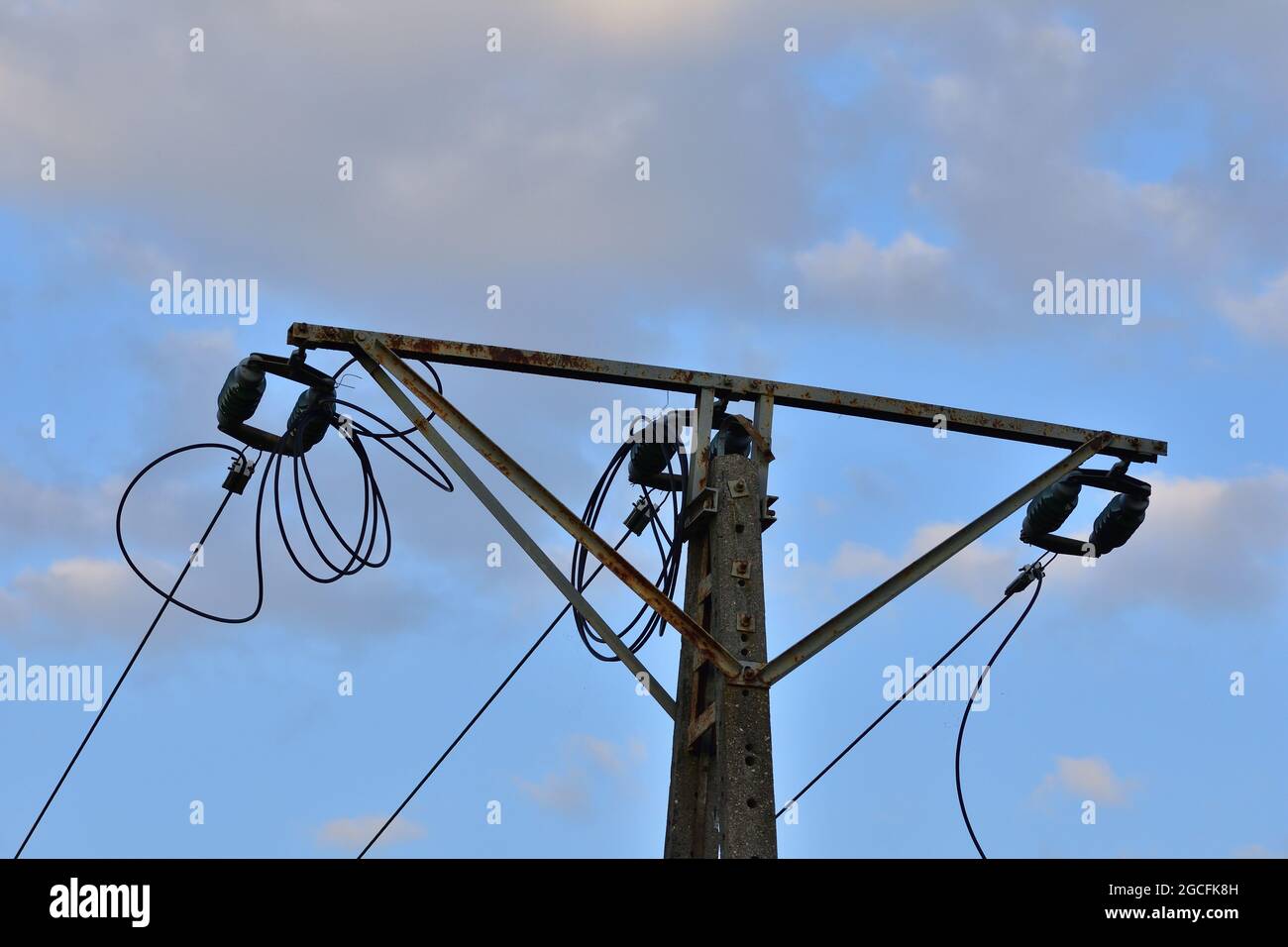 Old power pole disconnected from electricity, insulators and cables. Stock Photo